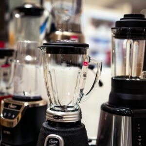 A variety of kitchen blenders displayed on a showroom countertop.