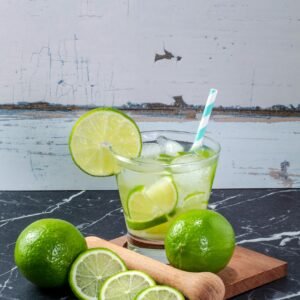 Chilled lime drink with fresh slices on a marble table, perfect for summer refreshment.
